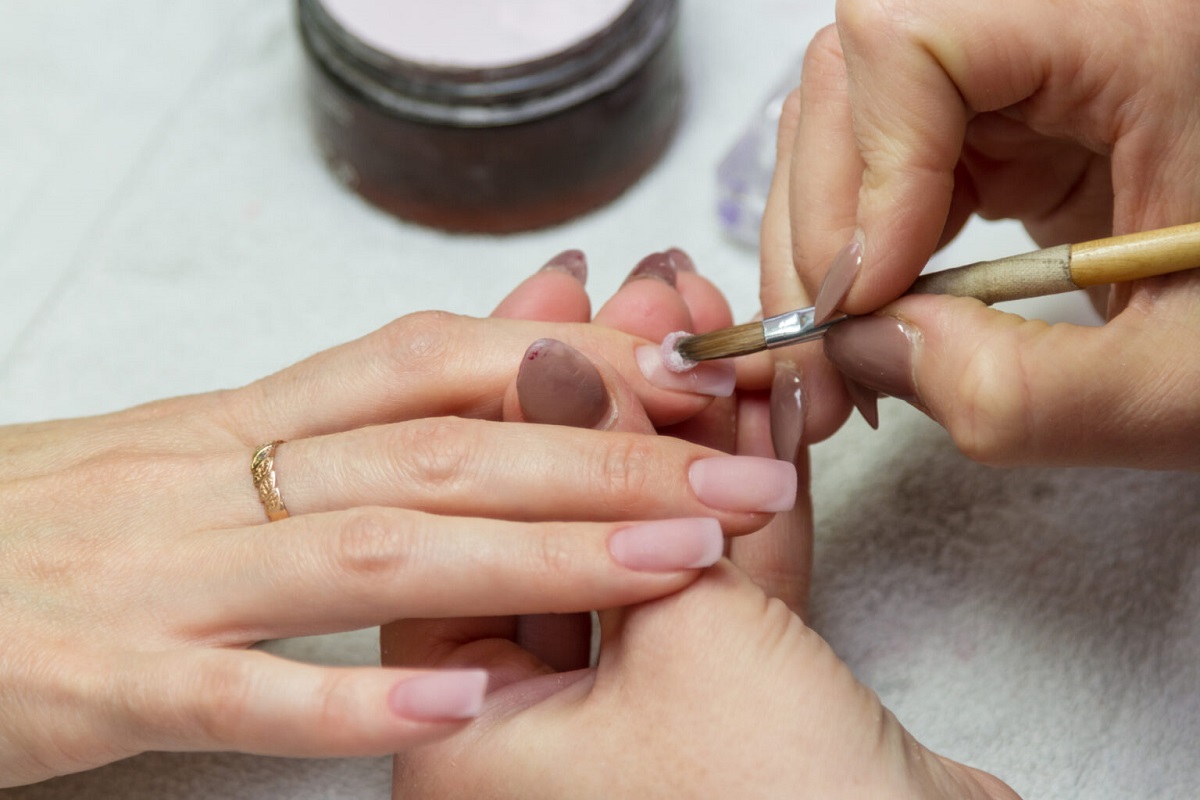 woman applying nail acrylic